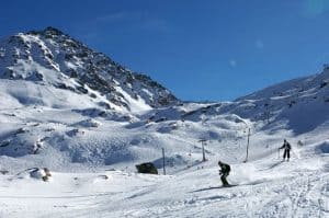 Snowy hills, people skiing off it