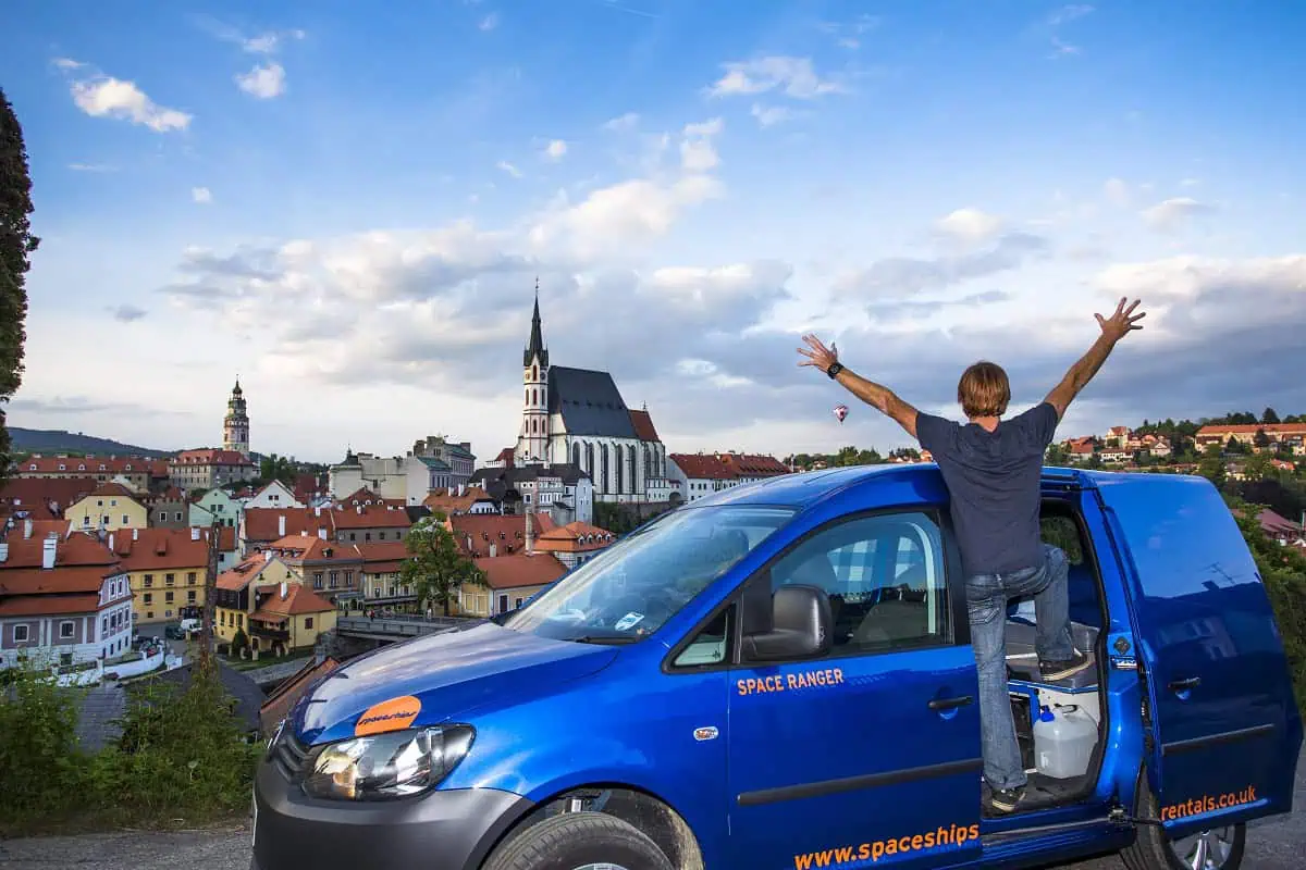Traveller standing on the side of their campervan overlooking a German city