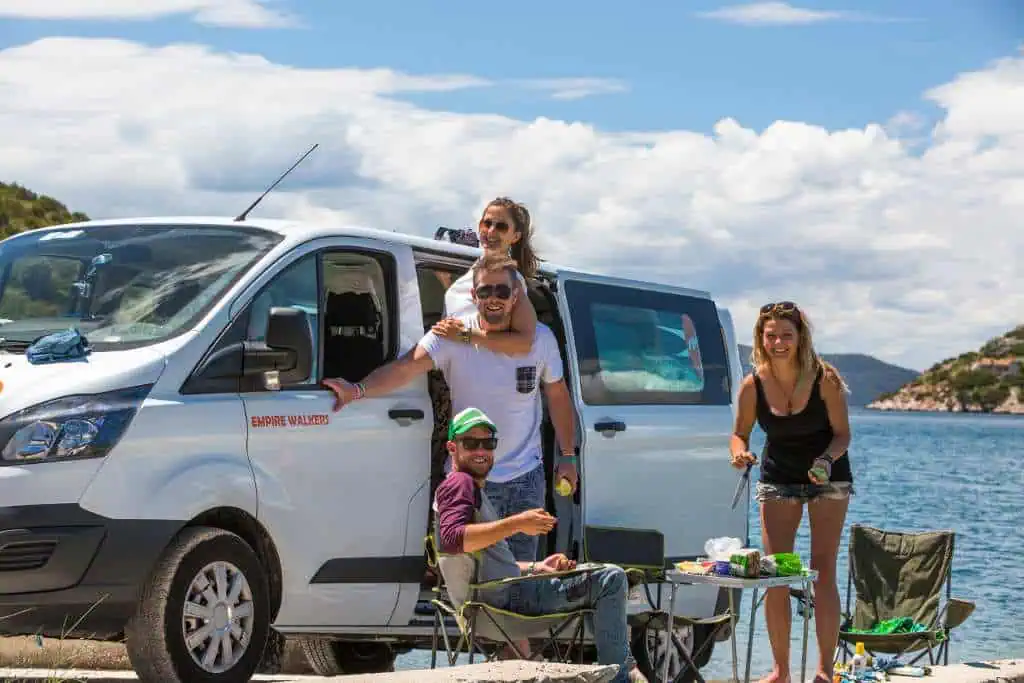 Travellers in front of a 4-berth campervan - Ford van model