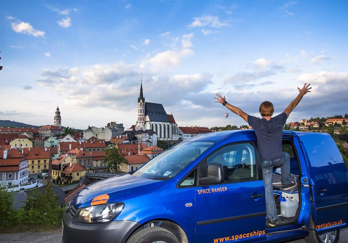 Traveller standing on the side of their campervan overlooking a German city